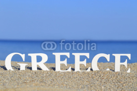 Seascape with white word Greece on the sand