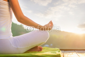 Fototapety Woman doing yoga on the shore - half figure sitting