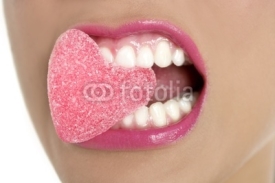 Naklejki Heart shape candy on woman macro mouth