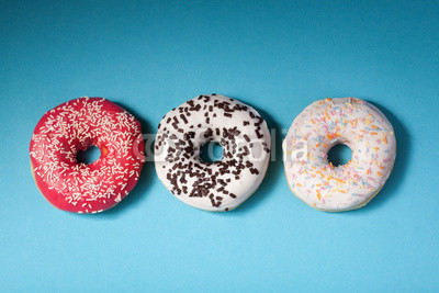 top view of three donuts isolated on blue background with copysp