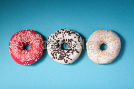 Naklejki top view of three donuts isolated on blue background with copysp