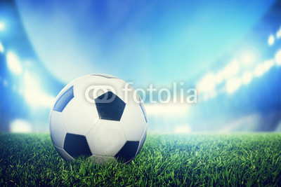 Football, soccer match. A leather ball on grass on the stadium