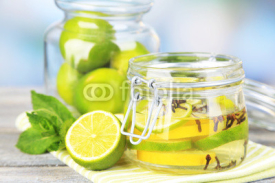 Fototapety Pickled limes and cloves in glass jar,