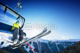 Naklejki Skier siting on ski-lift - lift at sunny day and mountain