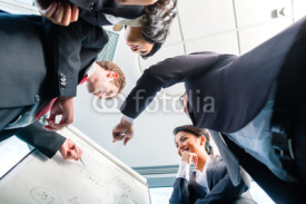 Obrazy i plakaty Asian Businesspeople looking at flipchart