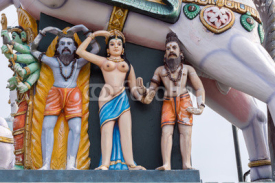 Madurai, India - October 21, 2013: Under the belly of a horse stand a half-naked, young woman and two bearded men.  All colorful statues at the shrine of Karuppana Sami near Nagamalai village.