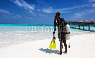 Weibliche Taucherin mit Ausrüstung am Strand der Malediven 