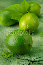 Naklejki Fresh limes on wooden table