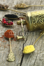 Naklejki Old spoons with spices and pepper grinder on wooden background