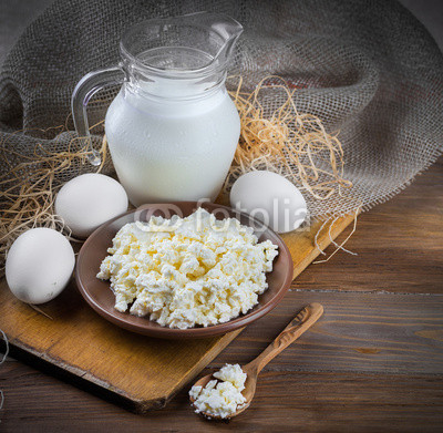 Milk and fresh eggs on a wooden board