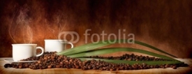 Fototapety Caffè in tazza, con chicchi sparsi sulla tavola