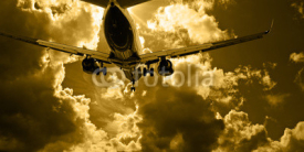 Fototapety Passenger jet landing against amber sky