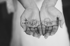 Fototapety Closeup of a woman holding wedding rings and engagement ring in her hands