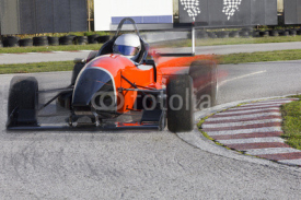 Fototapety Red bolide driving at high speed in circuit.