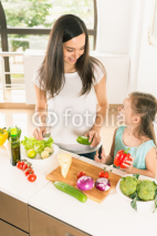Cute little girl cooking with her mother, healthy food
