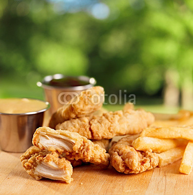 fried chicken strips with french fries and sauce.