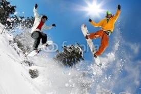 Fototapety Snowboarders jumping against blue sky