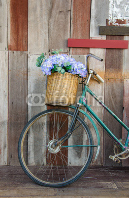 Old ladies bicycle leaning against a wooden plank
