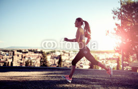 Fototapety Running athletic female exercising at sunset outdoors. Concept of sport, fitness and lifestyle. 