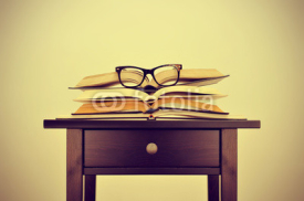 books and eyeglasses on a desk, with a retro effect