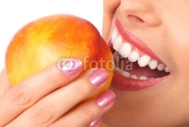 Obrazy i plakaty Beautiful young woman eating a peach. Isolated over white.