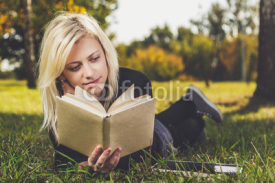 Naklejki girl reading in park on grass