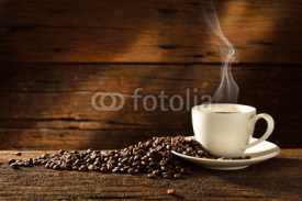 Obrazy i plakaty Coffee cup and coffee beans on old wooden background