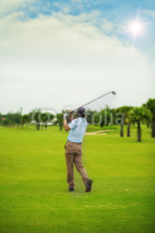 Naklejki Male golf player teeing off golf ball from tee box