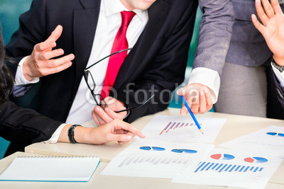 businesspeople anaylzing graph in office