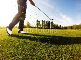 Naklejki Golfer performs a golf shot from the fairway.