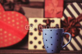 Naklejki Cup of coffee and gifts on background.