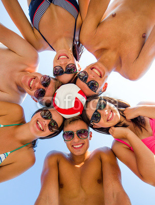 smiling friends in circle on summer beach