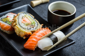 Fototapety Sushi with soy sauce eaten with chopsticks