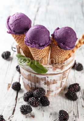Blueberry fresh ice cream scoops in cones on wood