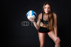 Naklejki Young girl holding volleyball on black background