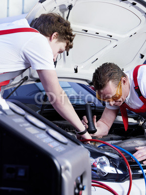 Two motor mechanic checking the air handling unit of a car