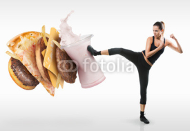 Fototapety Fit young woman fighting off fast food