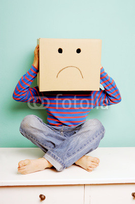 Trauriges Kind in einem Karton
