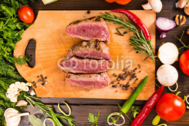 Naklejki Rare Roast Beef on Cutting Board with Ingredients