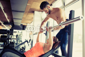 Personal trainer assisting with bench press