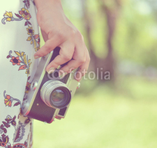 Naklejki Woman hand holding retro camera close-up