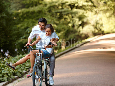 Happy couple cycling in the summer park