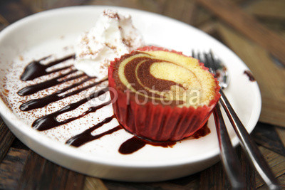 close up chocolate cupcake and sweet sauce in red paper cup