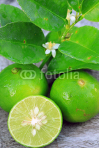 Naklejki Fresh limes on wooden background