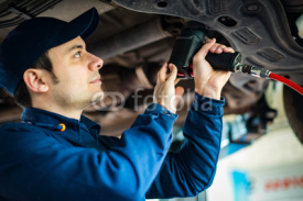 Mechanician changing car wheel in auto repair shop