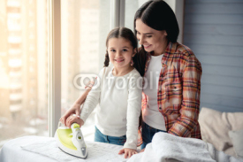 Mom and daughter ironing
