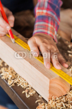 Obrazy i plakaty Carpenter's Hand Marking On Wood In Workshop