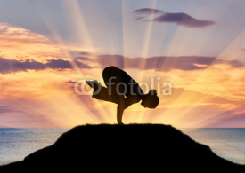 Fototapety Silhouette of a girl practicing yoga