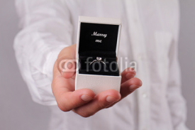 Close up of man hands holding gift box with with engagement ring. Merry me, Love, Wedding, Proposing, Marriage concept.