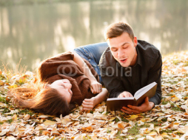 Naklejki young man reading to his girlfriend